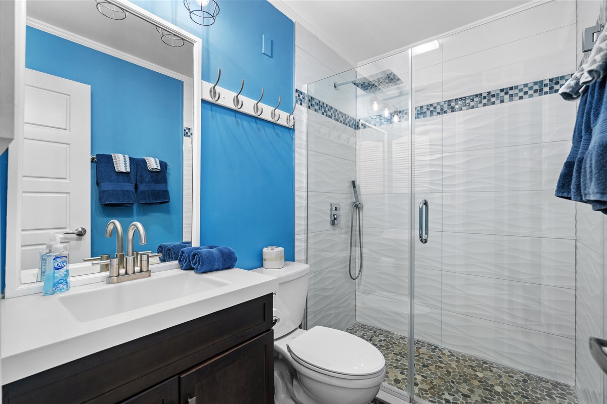 Newly renovated attached primary bathroom with large vanity and walk-in shower