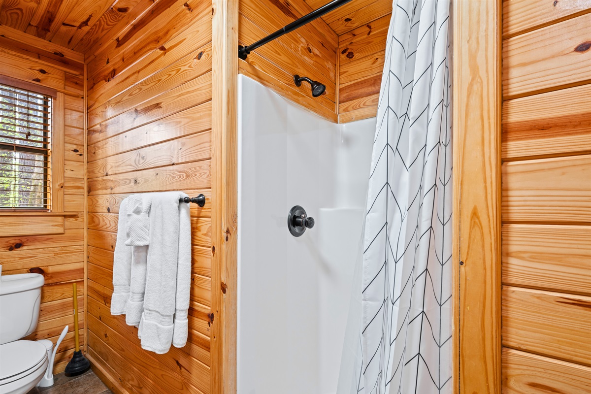 Featuring a walk-in shower, the space adds a modern feel while still blending with the cabin’s cozy design.