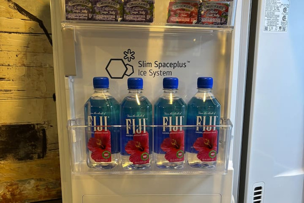 Hot and cold water dispenser with cups and convenient drink supplies.