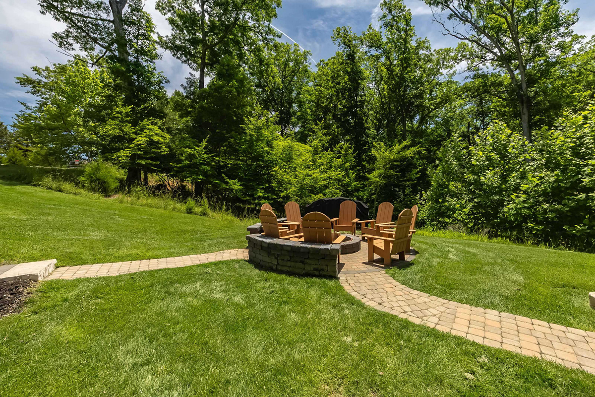 Relax around the fire pit beneath the trees.