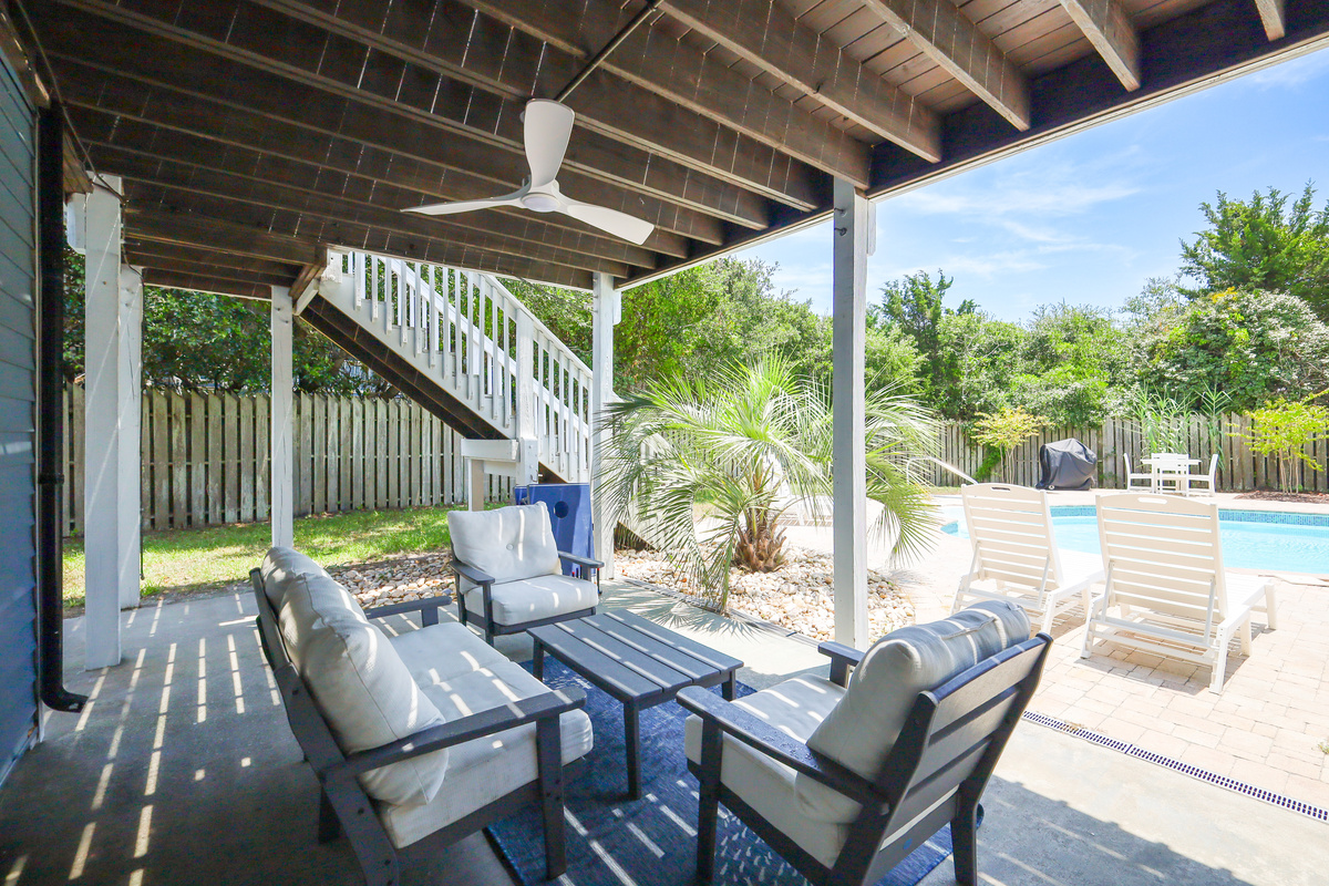 The shaded patio overlooks the private pool, offering the perfect spot to relax while staying cool