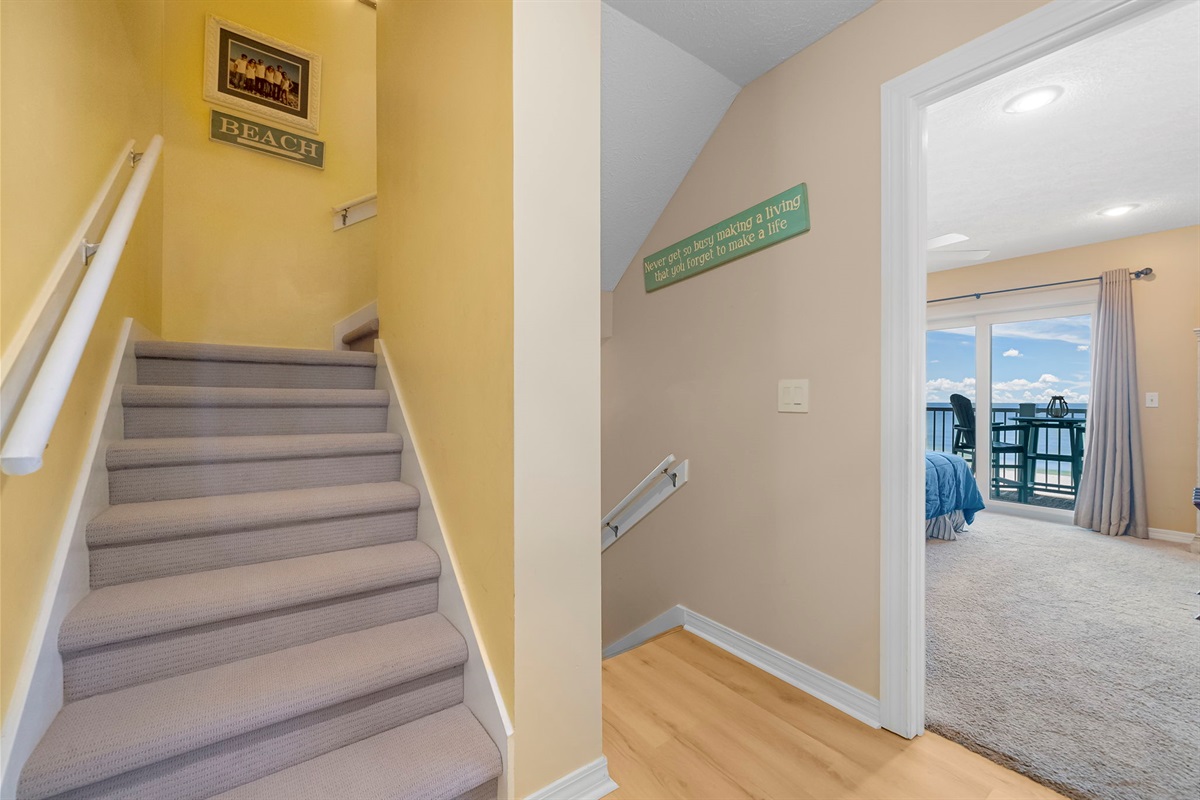 Welcoming second-floor entry with stairs leading to the private third-floor bedrooms.