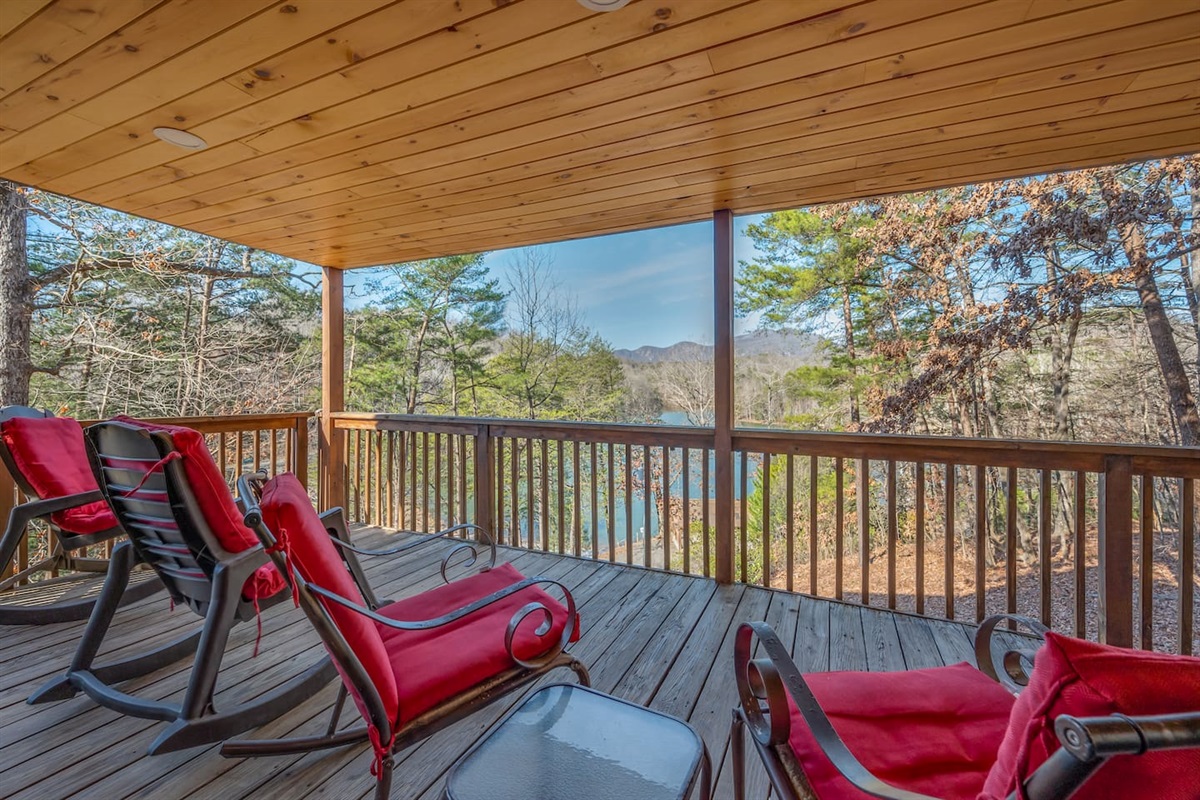 Fully enclosed wrap around deck with seating and large log picnic table- overlooking lake and beach area.