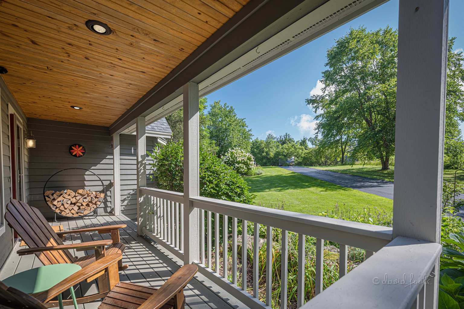 Welcoming front porch with two Adirondack chairs