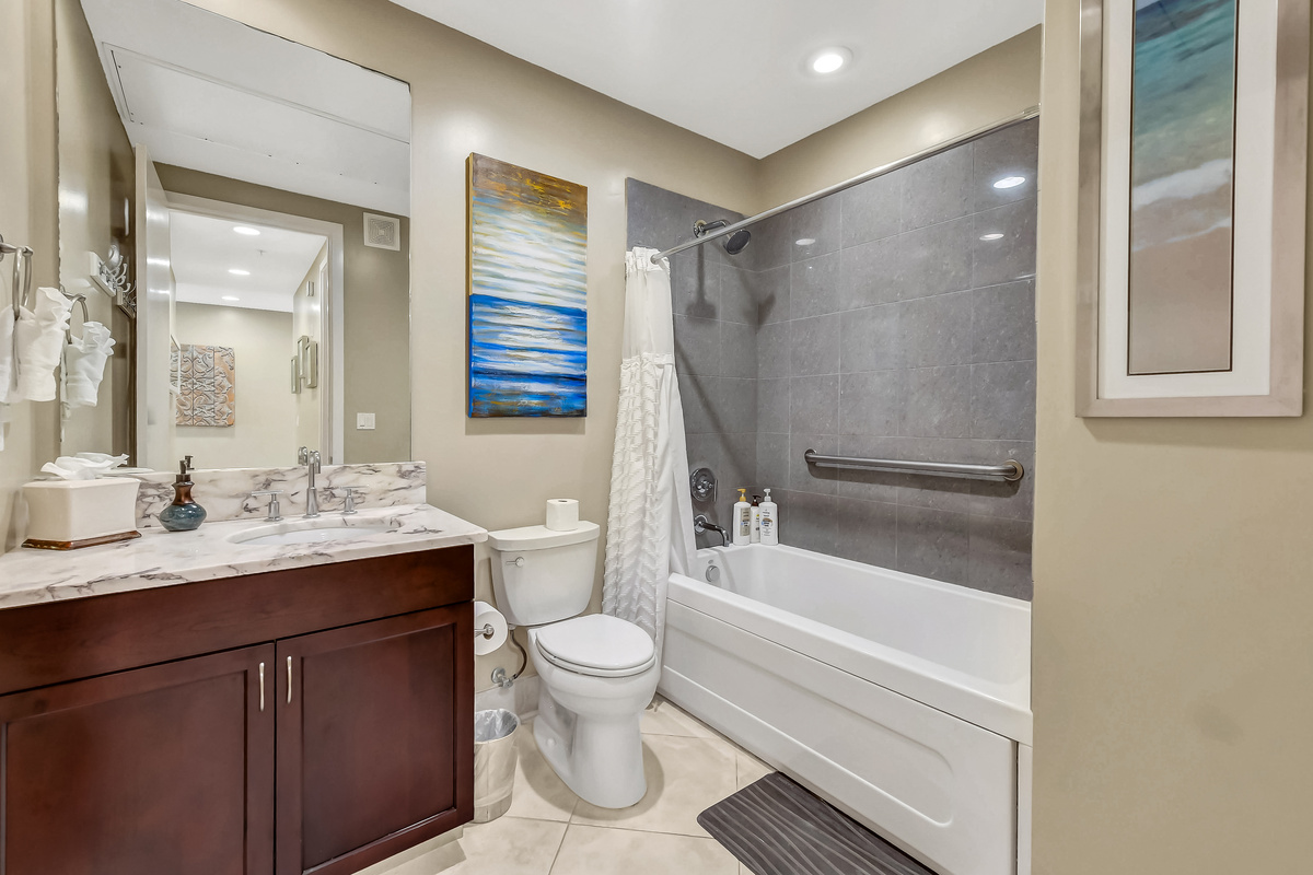 Guest bathroom with shower-tub combo and grab rail to meet all family needs.