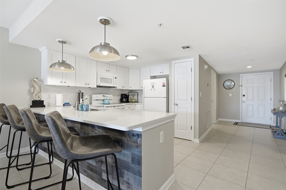 The kitchen has a clean white motif with counter dining seating for four.