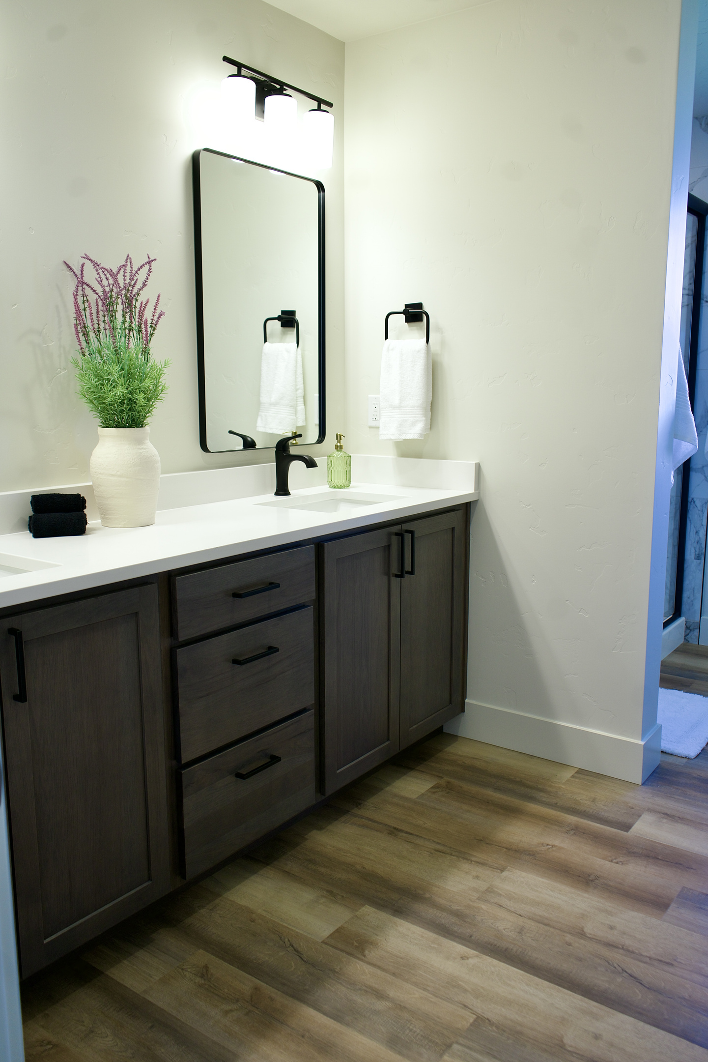 The second upstairs bathroom features a shower and bathtub combination, along with updated finishes and dual sinks, offering both convenience and a modern, functional design.