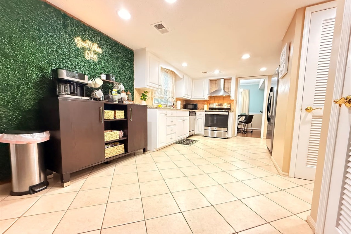 Full view of the kitchen and coffee station, showing open flow, ample lighting, and all essentials for extended stays.