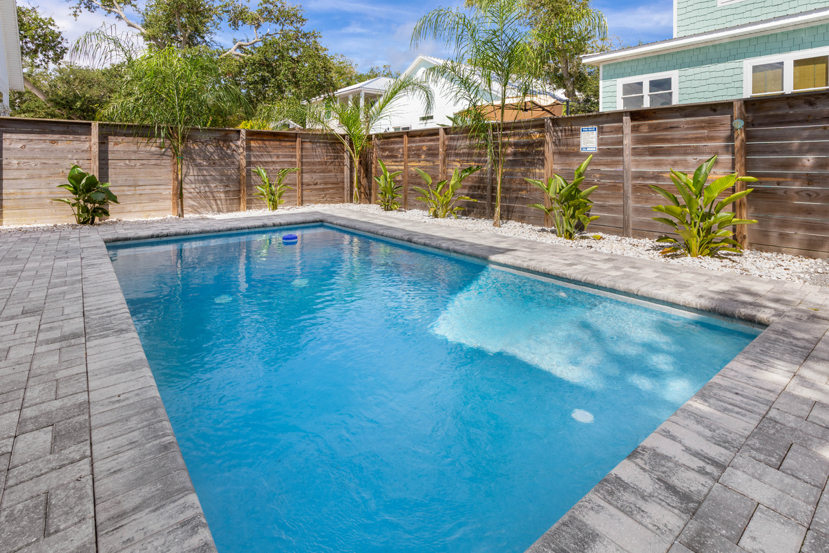 That shallow ledge at the near end is where the smallest swimmers spend the whole week, sitting in a few inches of warm water with a float in reach while the bigger kids cannonball in right behind them.