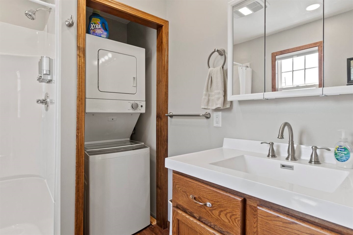 Full bathroom featuring a washer and dryer, combining convenience and functionality for a hassle-free stay.