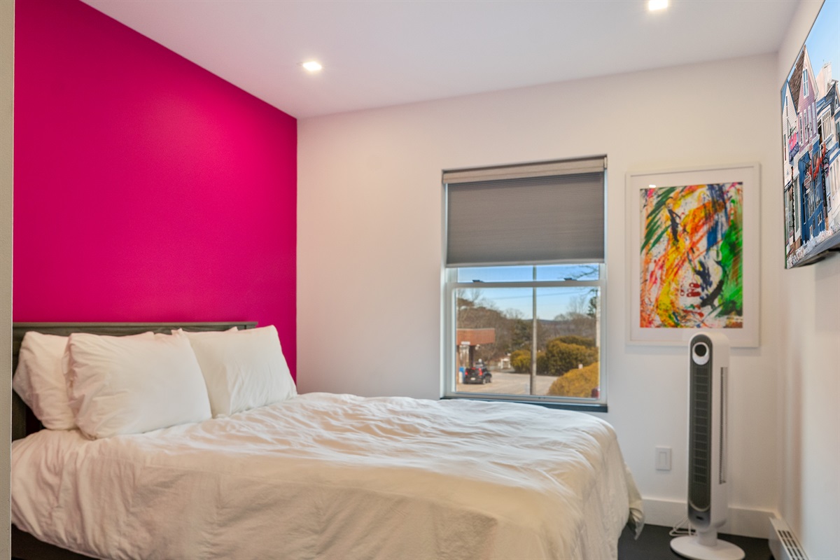 Bright guest bedroom featuring a Queen bed with a convenient Twin trundle tucked beneath. Perfect for extra guests, this room includes a high-powered oscillating fan for comfort and a wall-mounted TV for evening relaxation in downtown Bar Harbor.