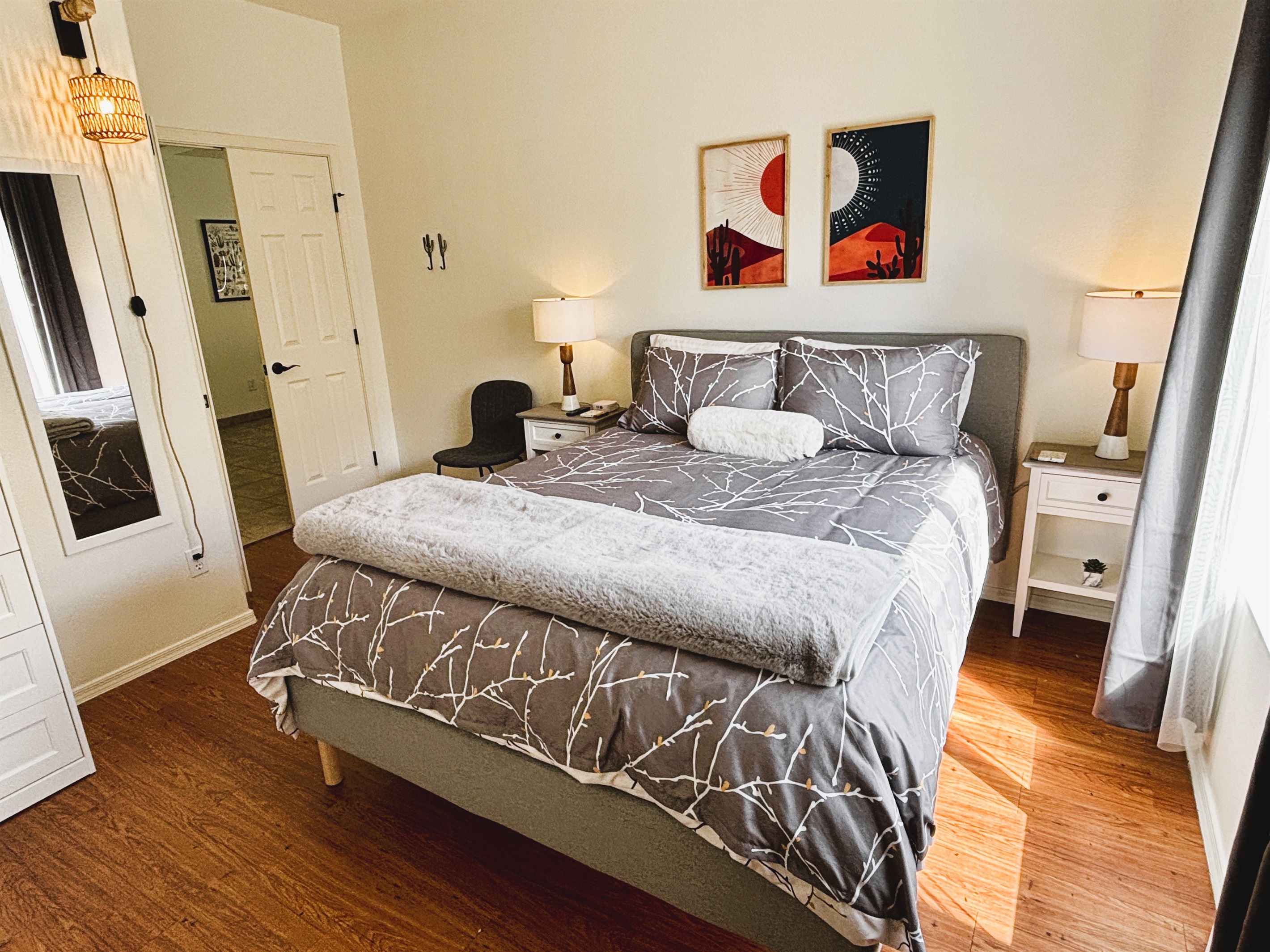 Bedroom with queen bed, smart TV, ceiling fan, blackout curtains and linens