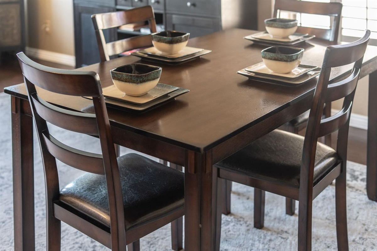 Set for four and ready for your first meal together — the rich wood dining table is the perfect spot to slow down, connect, and enjoy.