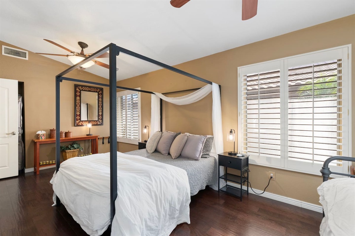 The canopy bed with its draped white curtains brings a romantic, boutique-hotel feel to the room — a thoughtful touch that makes guests feel like they're somewhere special.