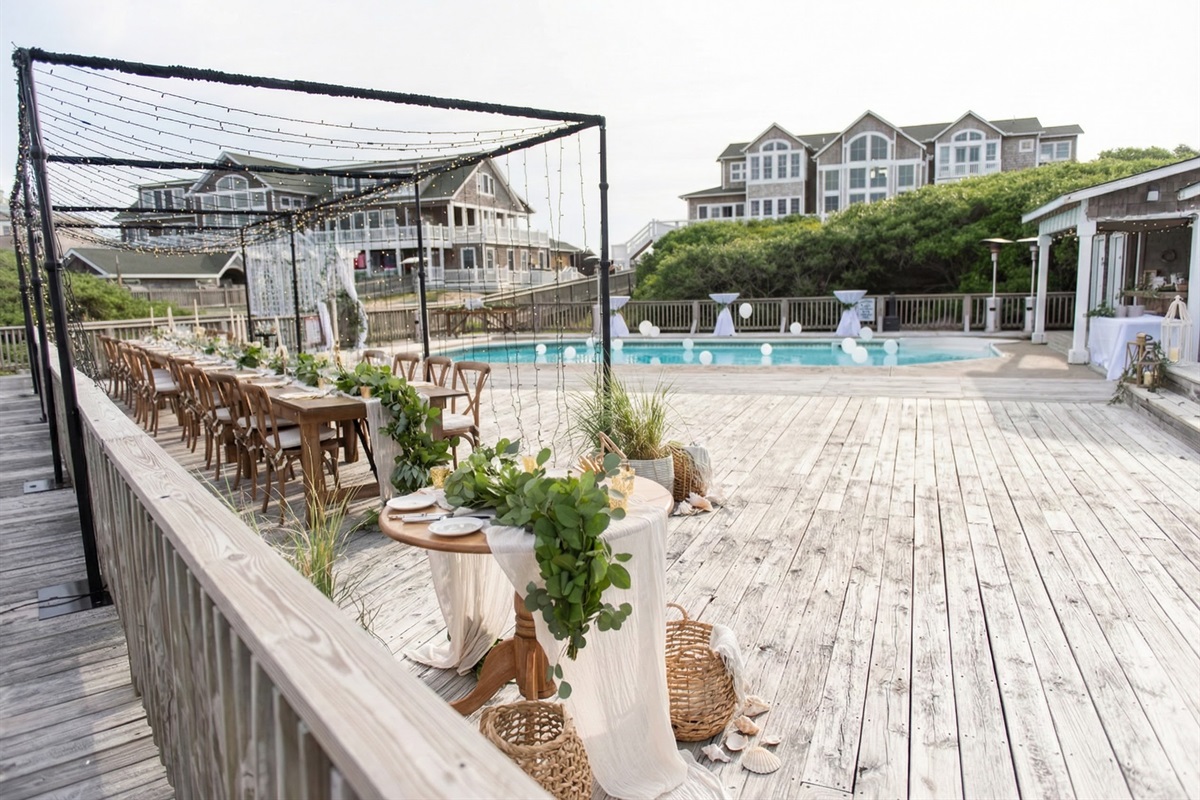 The expansive pool deck offers a versatile layout for ceremonies or receptions, easily accommodating long farm tables, cocktail stations, and decor against the backdrop of the dunes.