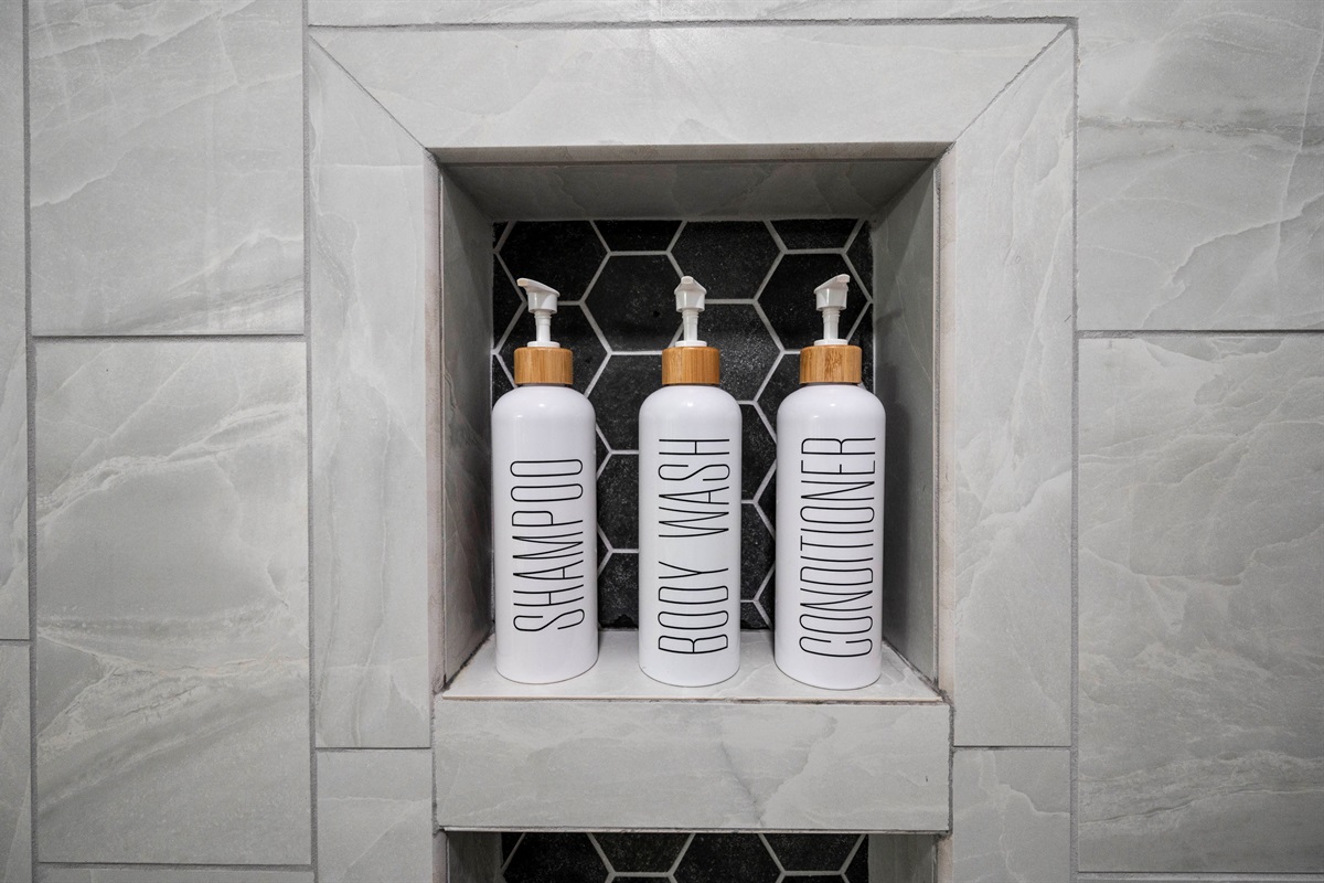 Sleek bathroom shelf with chic shampoo, body wash, and conditioner bottles.