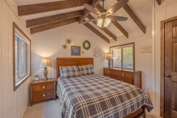 Upstairs bedroom with queen bed, fan, smart TV