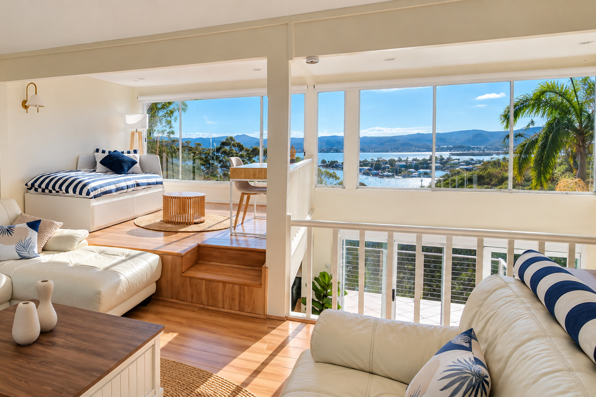 Relax in the sun-filled living area while enjoying panoramic water and mountain views through expansive windows.