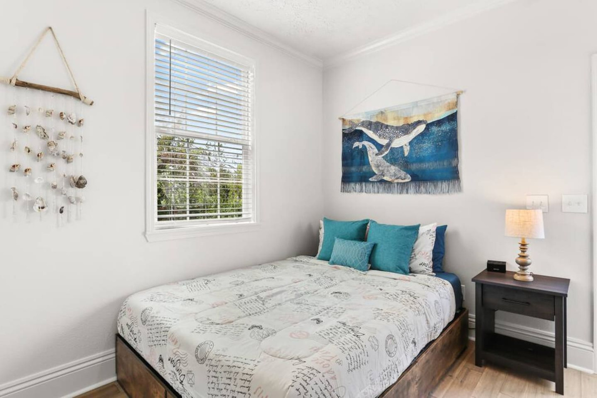 "Whitewater," the master bedroom has a Roku TV, queen bed, full en suite bathroom, direct back porch/yard access, and an ocean theme.  
