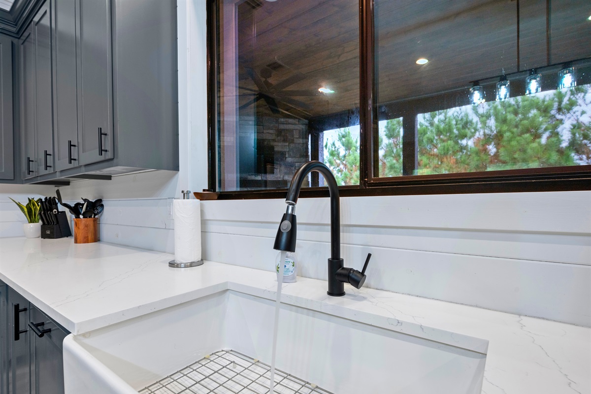Farmhouse sink and stylish fixtures in the open kitchen.