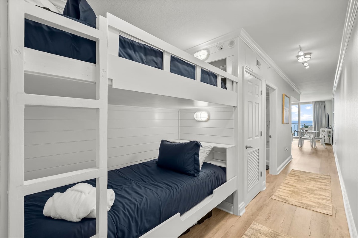 Cozy built-in hallway bunks with reading lights and storage—perfect for kids or extra guests. Just steps from the beach with ocean views right down the hall!