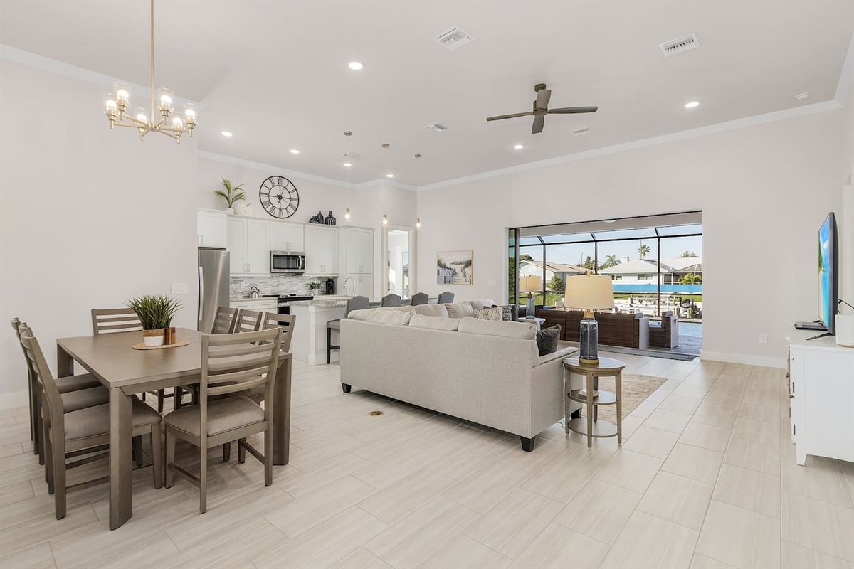 Spacious living room with captivating views of the pool and water!