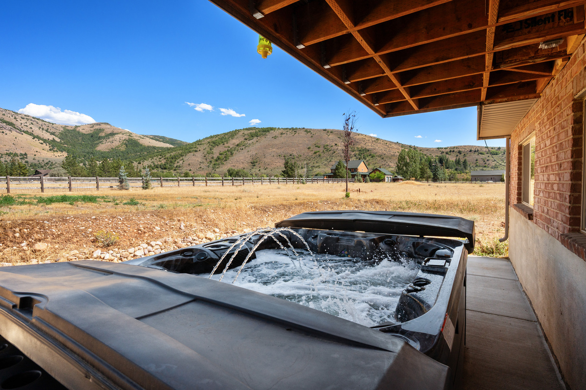Unwind beneath the covered patio in the private hot tub while enjoying broad views across the peaceful valley and surrounding hills.