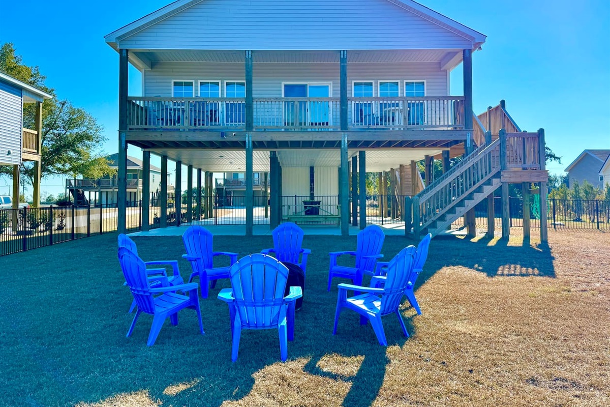 Private backyard dock with boat lift and fillet table, fenced-in backyard, fire pit with Adirondack chairs, hammocks, propane grill, picnic table, outdoor shower, expansive waterfront back deck with table and seating, neighborhood boat ramp and dock.