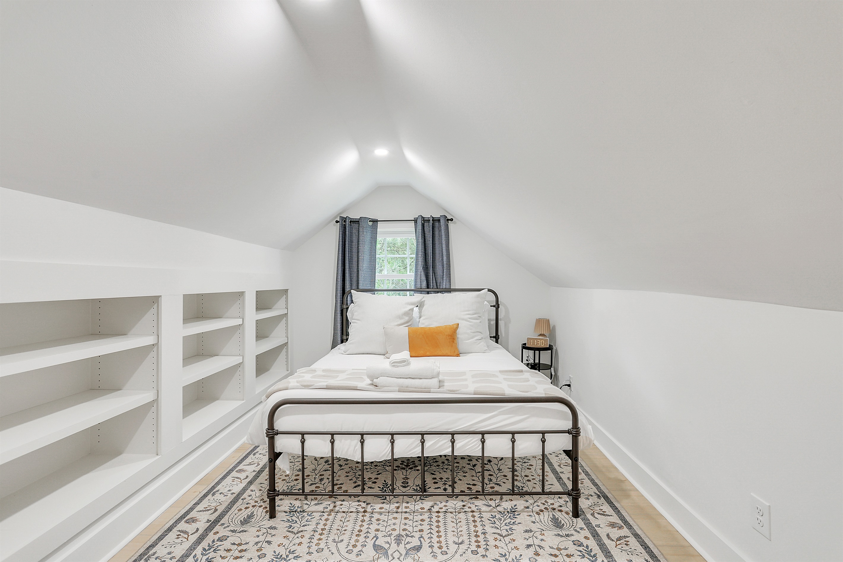 Quirky angled ceilings add character and charm to this cozy bedroom retreat
