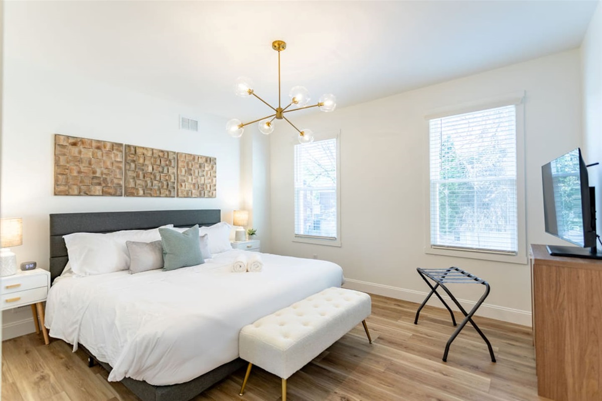 Full view of the bedroom featuring a king-size bed facing a flat-screen TV, creating a comfortable and relaxing space.