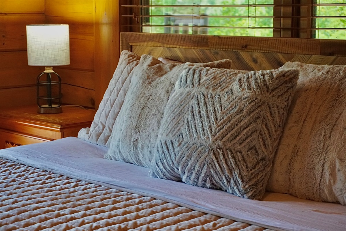 Plush pillows and warm wood create the perfect haven for relaxation and escapism!