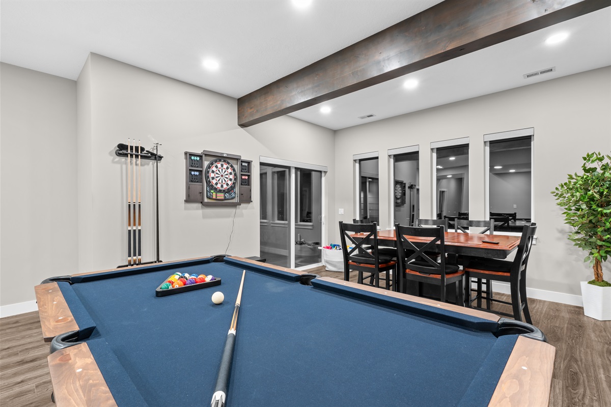 Entertainment-ready space with pool table, seating, and a game table, perfect for cards, board games, and group fun.