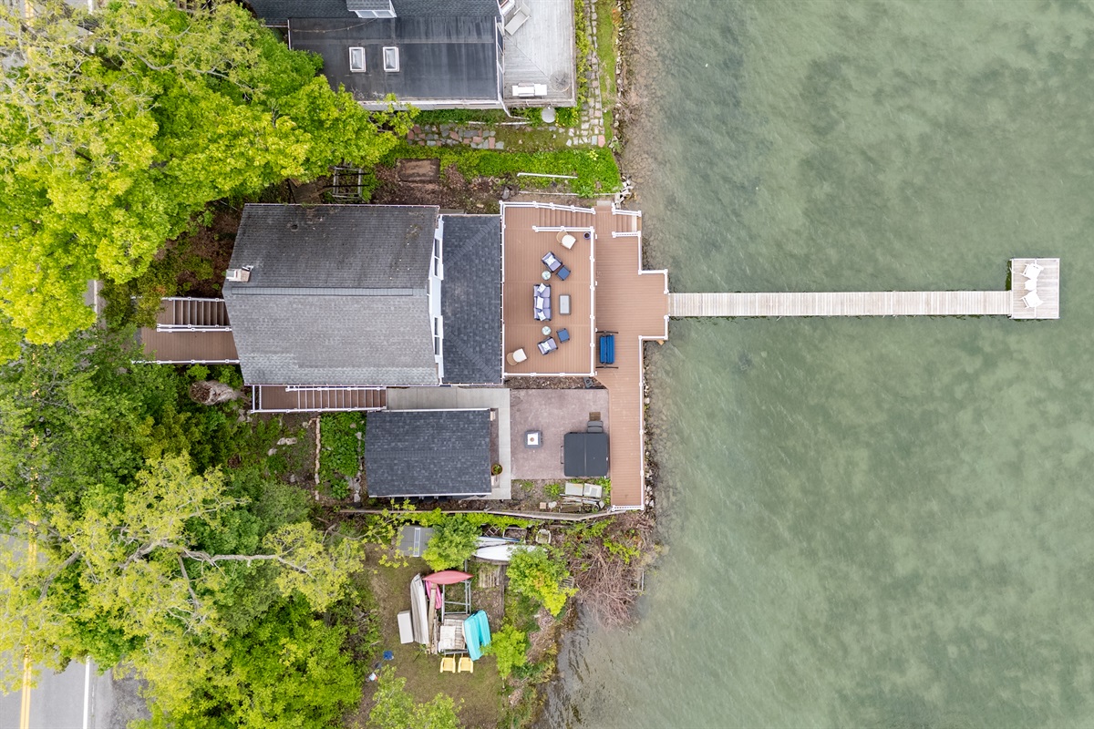 Aerial shot showcasing expansive lakefront entertaining space, hot tub, and private dock for the ultimate getaway 🎯🌊🍹