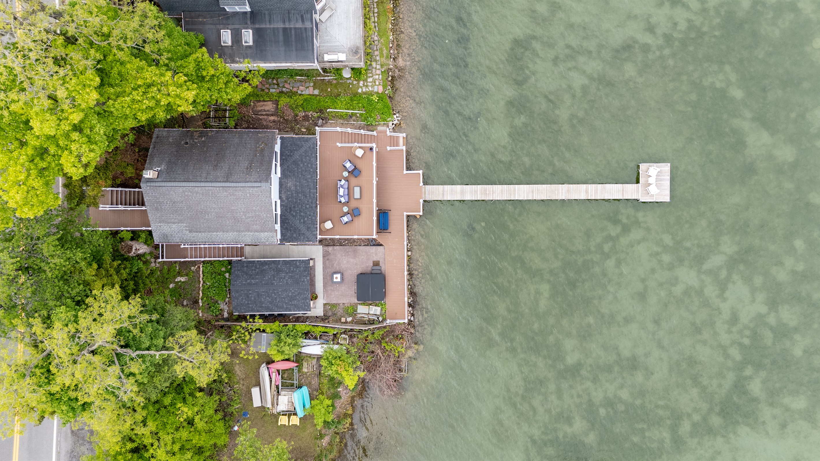 Aerial shot showcasing expansive lakefront entertaining space, hot tub, and private dock for the ultimate getaway 🎯🌊🍹