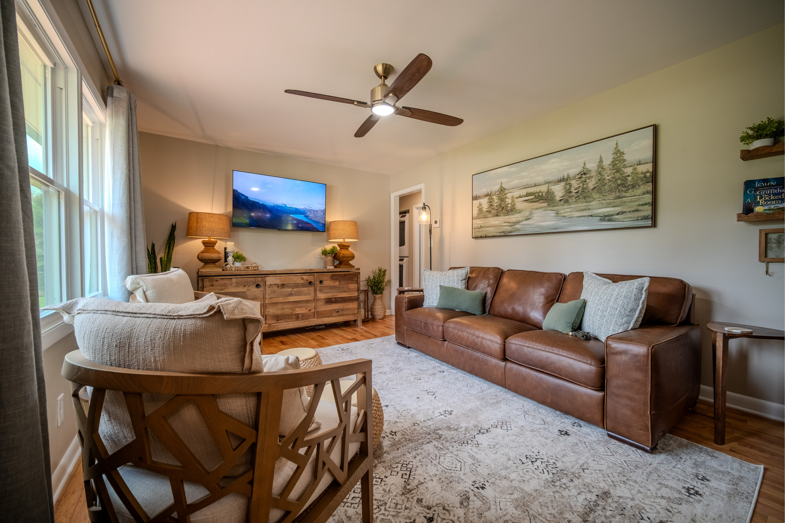 Gather, relax, and unwind in this thoughtfully designed living room with warm furnishings and plenty of natural light.