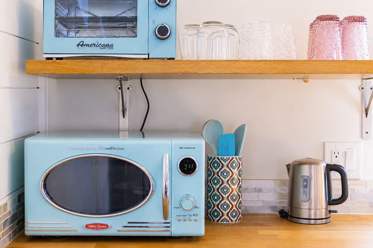 {Coffee & Tea Station} Retro-inspired coffee bar stocked with a kettle, microwave, toaster oven, and all the essentials for an easy start to your day.