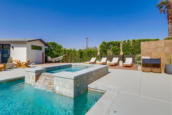 Outdoor space with several seating areas, pool chaise loungers
