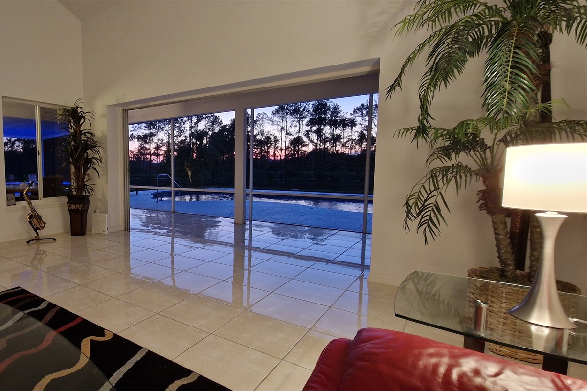 Living room view of pool and sunset