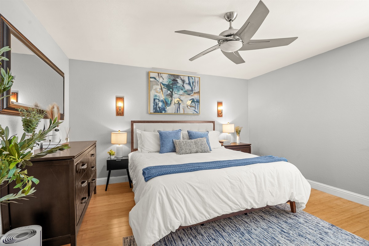 Spacious upstairs primary suite featuring a king bed and ensuite bathroom with dual sinks.