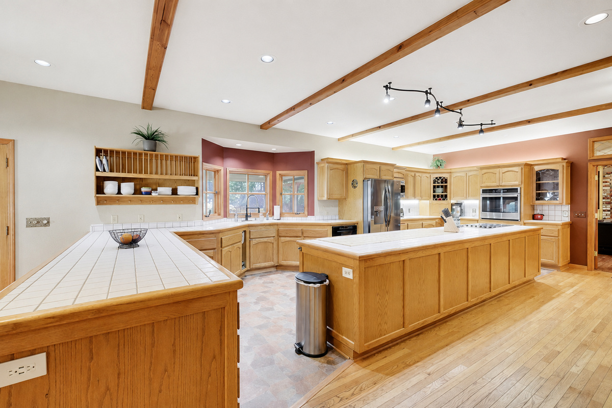 Spacious full kitchen with large gourmet island, wood cabinetry, stainless steel appliances, and plenty of prep space for group meals.