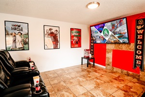 A crisp white wall sets the stage for a sleek TV, with a popcorn machine ready to churn out theater-style popcorn.