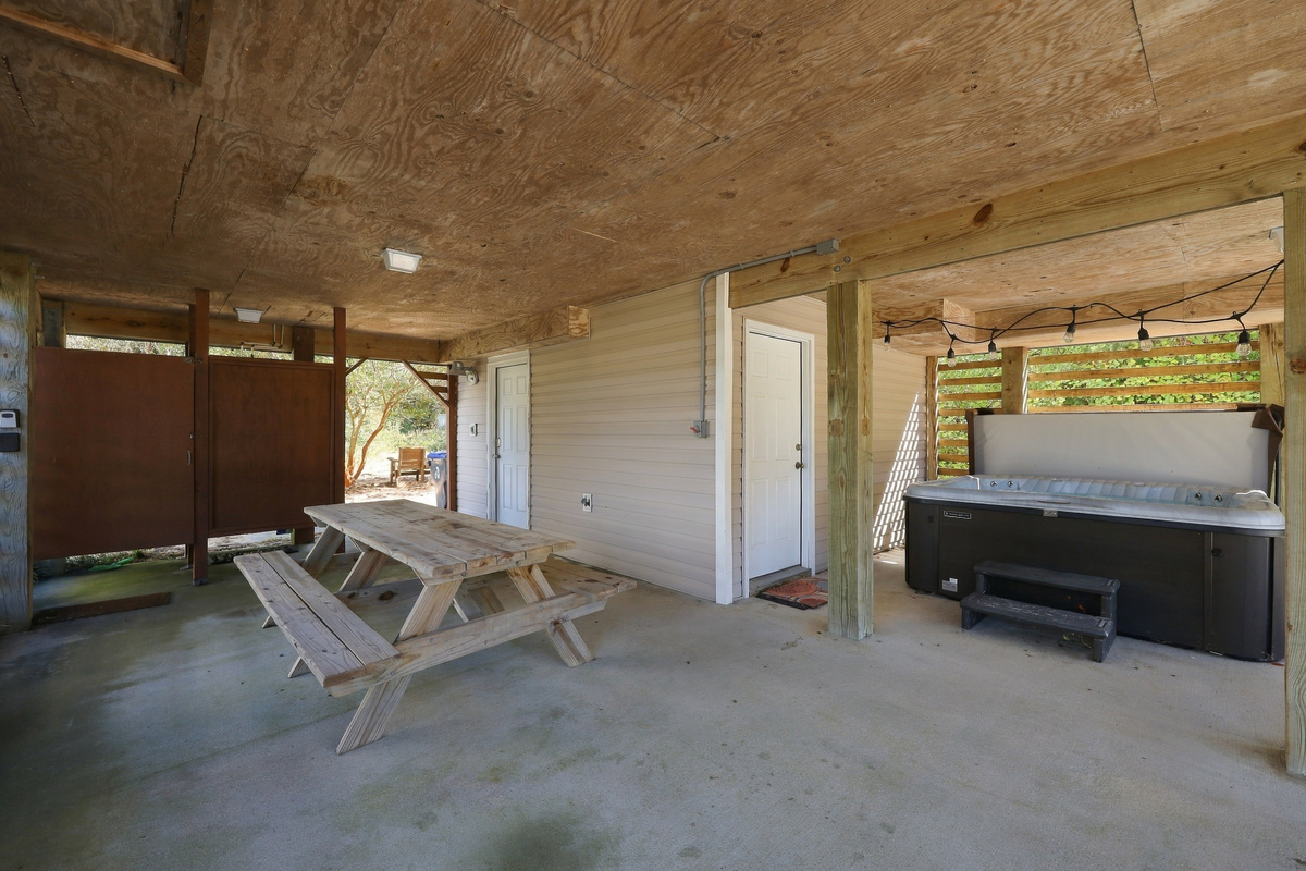 Ground-level hangout: picnic table, hot tub and outdoor shower, all in the shade.