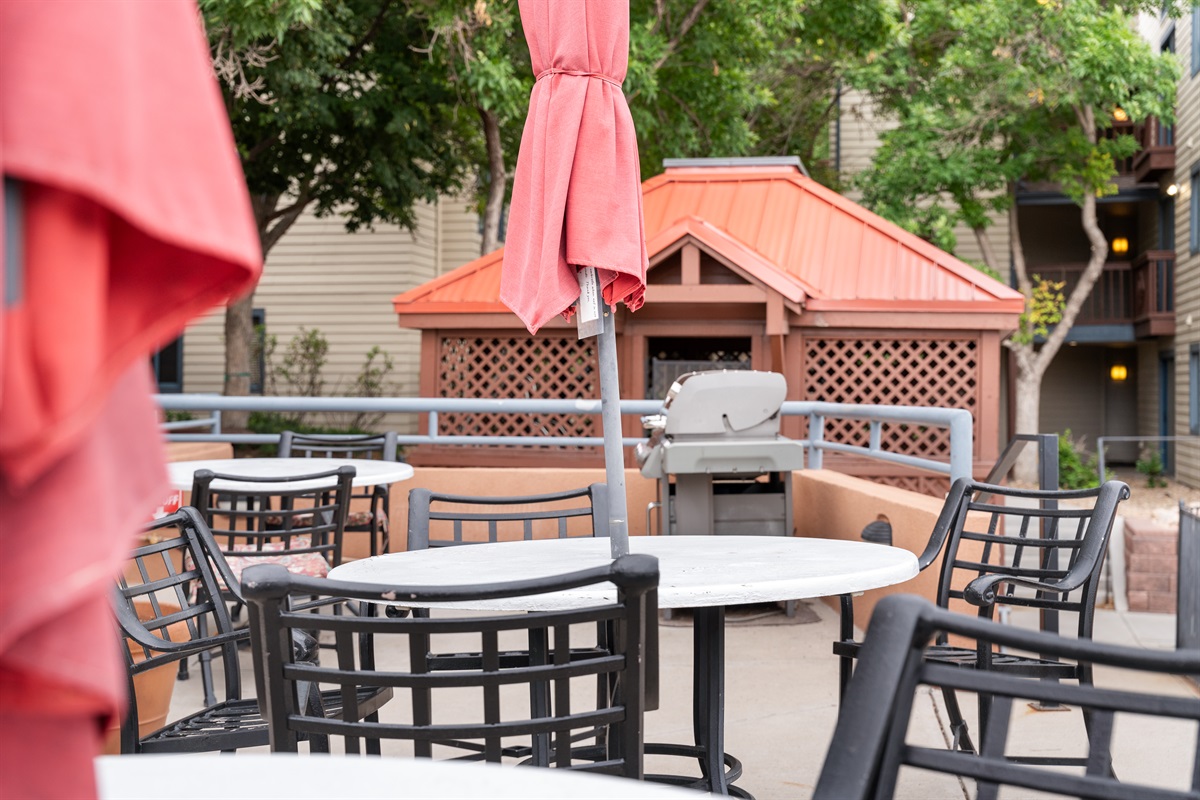Outdoor communal seating, gas grill and umbrellas.