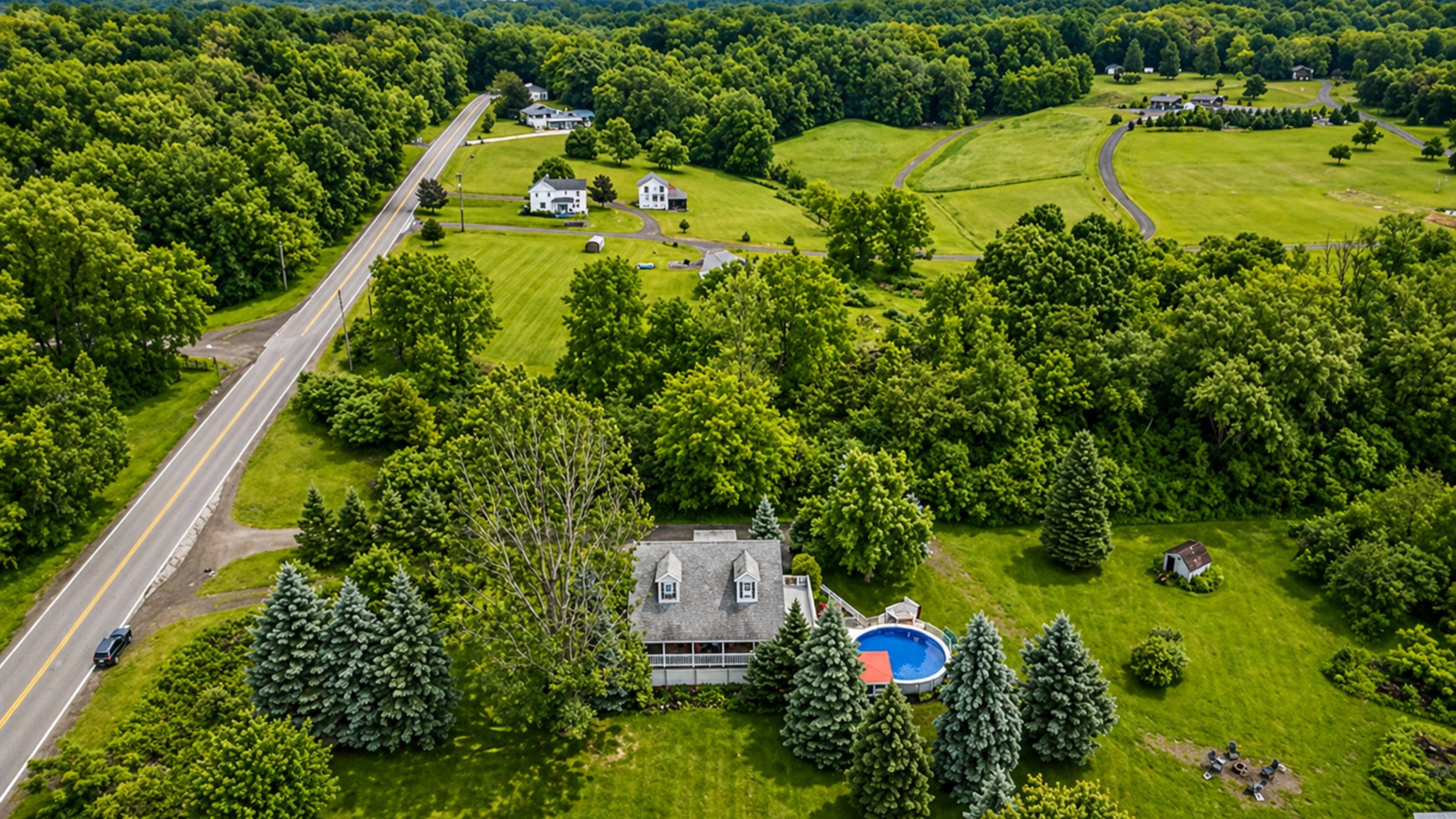 This picturesque property features a charming home, a refreshing pool, and lush greenery, offering a serene countryside retreat.