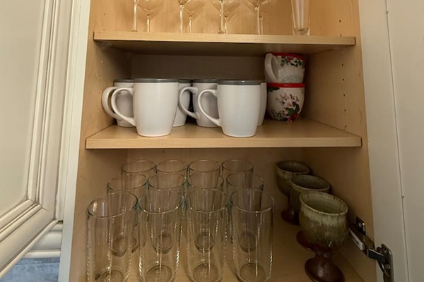 Mugs & Glasses: A close-up view of the stocked glassware and coffee mugs, highlighting the ample supply for all guests.