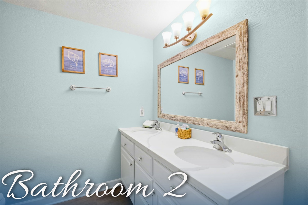 Bathroom 2 includes plenty of counter space and a bright coastal feel throughout.