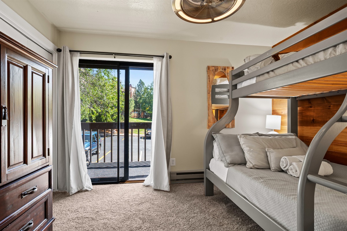 Stylish bunk room with modern lighting and easy access to the deck.