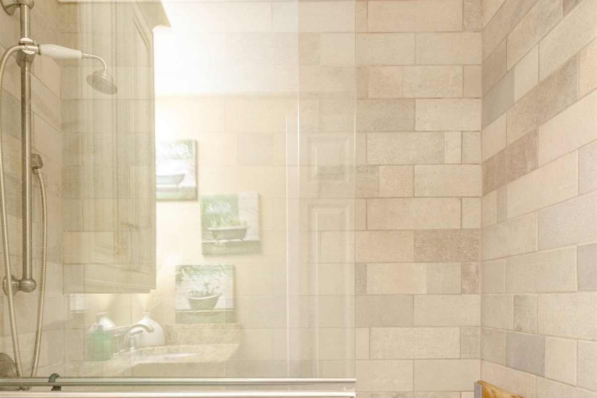 The master bathroom features glass sliding doors.