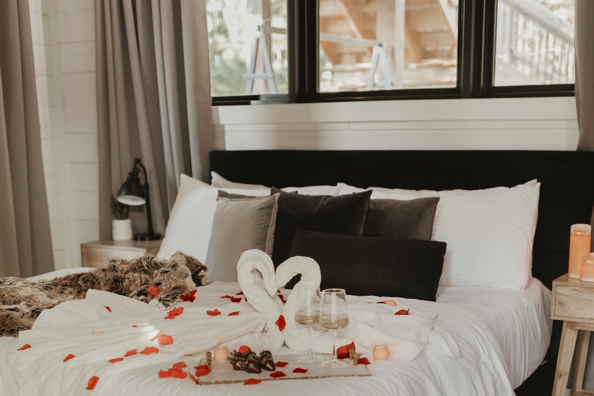 Romance awaits—plush bedding, swan towels, and rose petals set the mood for an unforgettable stay. Whether it’s a honeymoon, anniversary, or just because, this cozy retreat is made for love under the pines.