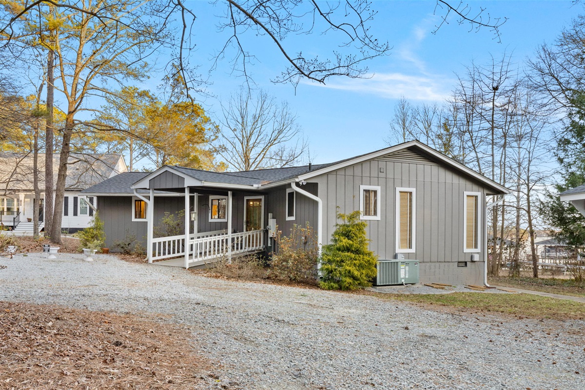 Charming Exterior: Embrace lakeside tranquility in this inviting retreat surrounded by nature!
